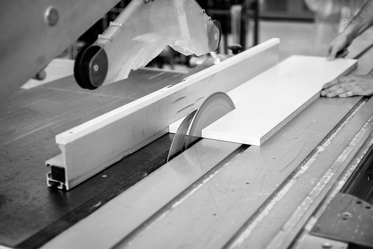 Worker,In,A,Furniture,Factory,Cutting,A,White,Wooden,Plank