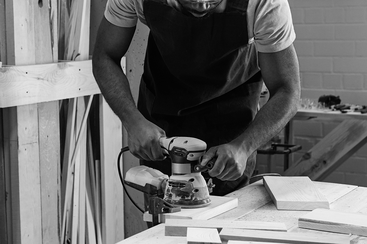 Waist,Up,Portrait,Of,Mature,Black,Carpenter,Sanding,Wood,Using